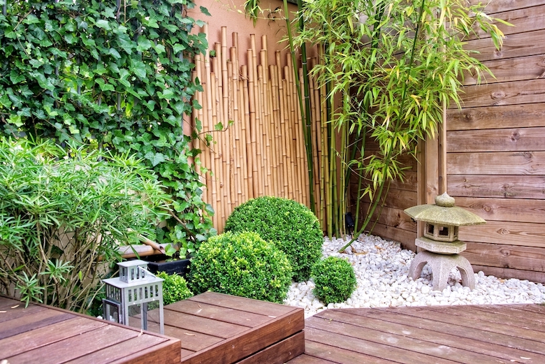 Bambou utilisé comme clôture avec des arbustes verts